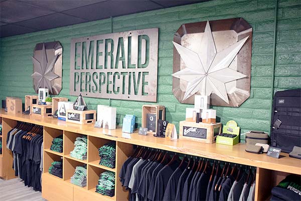 Interior image of smoking accessories near Junipero Serra Park, Ventura CA featuring display sign along with clothing for retail.